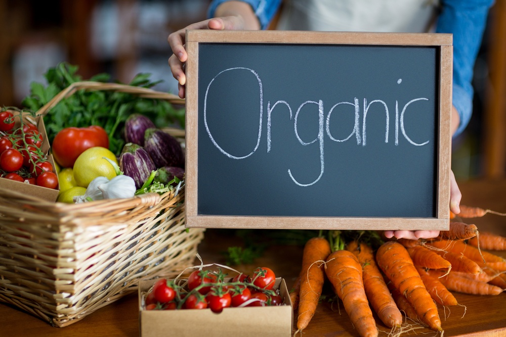 Female staff holding organic sign board in supermarket.jpeg